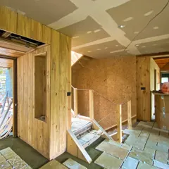 An interior during the fit-out stage, showing stone floor tiles being laid next to newly installed wood paneling. This phase is where the textures and character of a space begin to emerge.