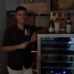 Our sommelier Udiksh standing by the wine cooler where we store our curated collection. His expertise ensures every bottle, from Moët to lesser-known gems, is ready for you to enjoy by the glass.