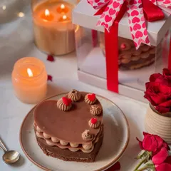A heart-shaped chocolate brownie cake, elegantly piped and decorated for Valentine's Day. It's a rich and indulgent dessert, perfectly sized for two to share.