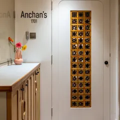 First impressions matter. This entryway features a custom door with an artistic metal and glass grill, paired with a sleek wooden shoe cabinet for a welcoming and stylish space.