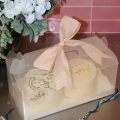 A perfectly packaged Rakhi gift set featuring two custom bento cakes in a clear box with a ribbon. It's a sweet and simple way to send love to your sibling on this special day.