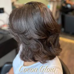 The Cocoa Glow gives this layered bob a soft, radiant finish. It's a subtle and sophisticated global color that proves you don't need dramatic highlights for a big impact.