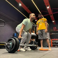 Proper coaching makes all the difference in heavy lifts. I am closely supervising this client's form during a heavy trap bar deadlift to ensure his back remains straight and the lift is performed safely and effectively.