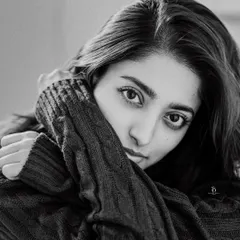 A striking black and white close-up of actress Ishaa Saha. The tight framing and her direct gaze create a powerful and intimate portrait that highlights her expressive eyes.