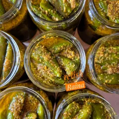 My Stuffed Green Chilli Pickle, or Hari Mirch ka Bharwa Achaar, is a North Indian favourite. I use a special medium-spicy chilli called Achaari Mirchi, slit it, and stuff it with a flavourful masala. This top-down view shows the jars just after packing, with the chillies soaking in mustard oil.