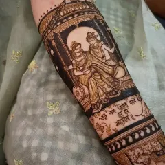 For brides who want a spiritual touch, I create divine portraits like this one of Shiva and Parvati on a swing. This image shows the design after the henna paste has been applied, with a sacred mantra written below to add a special blessing to the bridal art.