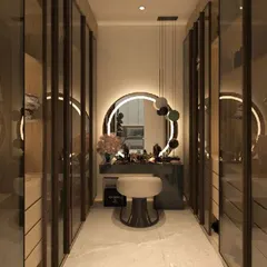 A glamorous walk-in closet with a dedicated makeup vanity at the end. The circular back-lit mirror and glass wardrobe doors create a bright and stylish space.
