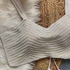 A close-up of my beautiful pearl moti spaghetti blouse in white. This trendy, padded blouse is handcrafted from pure silk and features heavy pearl work, making it a versatile and glamorous addition to your wardrobe.