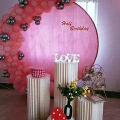 Celebrating the half-way mark to one! This sweet half-birthday decoration uses a pink backdrop and a matching balloon garland to create an adorable photo spot.