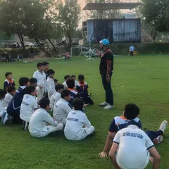 A coach leads a group discussion with our junior players. It is important to develop their thinking about the game, not just their physical skills.