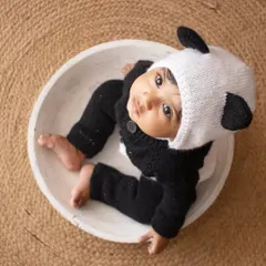 An aerial view of the cutest panda in town, sitting in a white bowl against a rustic jute mat.