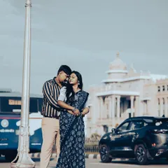 A retro-style shot of a couple in front of the Vidhana Soudha, with classic cars and a vintage color grade giving it a nostalgic feel.