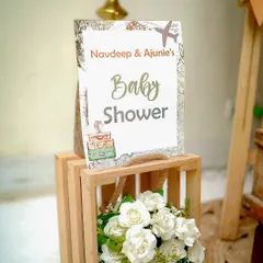 A personalized sign for Navdeep and Ajunie's baby shower. The design incorporates a vintage map and travel motifs to perfectly match their unique "Adventure Begins" theme.