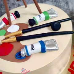 A close-up of the artist cake, showing the detail on the tiny fondant paint tubes and brushes.