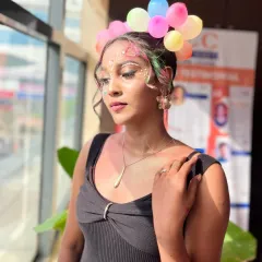 A creative makeup and hair look inspired by the festival of Holi. This student's work features playful face art and a unique balloon-adorned hairstyle, showcasing fuori-of-the-box creativity.
