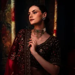 Capturing the quiet elegance and intricate details of this traditional ensemble. The moody lighting and rich, dark background make the delicate jewelry and embroidery the true focus of the portrait.