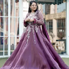 A full-length portrait of the bride, her magnificent gown flowing around her, capturing a moment of quiet grace.