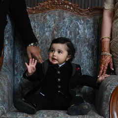 A precious moment captured. This tiny tuxedo is perfect for a family wedding, ensuring the youngest members of the party are just as stylishly dressed.
