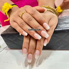 This is a beautiful example of a "baby boomer" or ombre French manicure. The seamless blend from a soft pink base to a white tip creates a natural and very elegant look on these square-shaped nails.