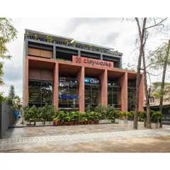 The completed Clayworks building in Koramangala, featuring a robust brick facade that adds warmth and texture to the urban streetscape. The deep-set windows and strong vertical lines create a powerful architectural statement.