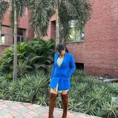 This shot shows how the long blazer and high boots work together to create a balanced, high-fashion silhouette that's still wearable for a day out in the city.