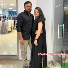A happy couple posing in my store. She looks effortlessly chic in the black ruffled saree, proving that black is always a good idea for an elegant evening.