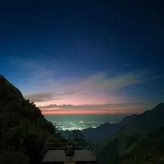 A stunning night view from a viewpoint near our Munnar camp, with city lights twinkling far below under a star filled sky.