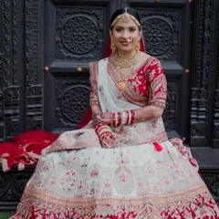 This bride's look is rooted in tradition and enhanced with elegance. Her white and red lehenga is complemented by makeup that feels as timeless as her vows.