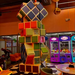 A look at our colorful and fun decor, including a giant Rubik's cube structure and classic claw machines in our arcade area.