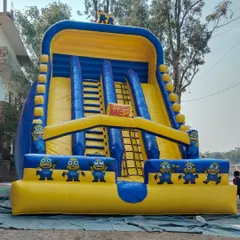 A full view of the Minions-themed inflatable slide. You can see the dual slides and the climbing nets in the center, all decorated with the funny Minion characters.