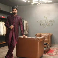 Confidence in craftsmanship. The model leans against a leather chair in our studio, wearing the fully embroidered Indo-western set, projecting an aura of effortless style and sophistication.