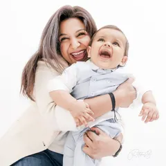 The sound of a baby's laughter is the best thing in the world. This candid shot of a mother and her baby sharing a moment of pure, uninhibited joy is what family photography is all about.