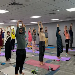 In a conference room at Manhattan Associates, I led a session focused on posture and flexibility. This standing stretch helps counteract the effects of sitting, promoting better alignment and energy flow for the entire team.