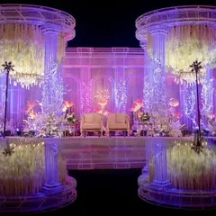 A closer look at the twin Romanesque pillars framing the stage. These structures were filled with cascading floral arrangements and illuminated from within, creating a soft, ethereal glow for this grand reception.