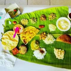 A beautiful top-down view of a traditional oota. You can see the perfect placement of salt, pickle, palyas, kosambari, holige, and rice, all ready for the guests to enjoy.