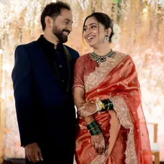 A classic reception look with an elegant royal touch. The bride's radiant glow and stunning silk saree are perfect for her special evening, seen here sharing a laugh with her husband.