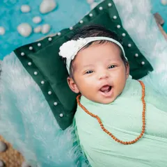 A sweet, smiling newborn enjoys the Maha Shivratri theme. This close-up shot captures an awake and happy baby, showing that we can capture beautiful expressions even when they aren't asleep.