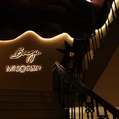 The stylish entrance to the 'Bougie Miso Sexy' lounge, capturing the venue's chic ambiance with its neon sign and elegant staircase.