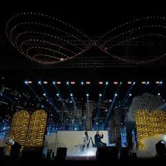 The stage is our canvas. This wide shot showcases the scale of our production, featuring a multi-layered set, an infinity-symbol lighting rig, and atmospheric smoke, setting the scene for a truly grand sangeet night.
