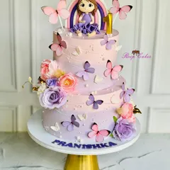 A magical two-tier cake for a very special first birthday. This design features a beautiful lavender and pink ombre effect, a custom fondant doll, and delicate butterflies, all coming together to create a fairytale celebration.