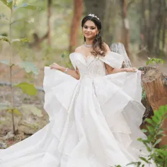 A full-length shot of the bride in a forest setting, looking like a princess. The voluminous gown is paired with a simple, elegant makeup and hair look.