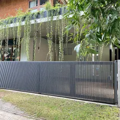 The custom-designed sliding gate for "House of Greens." The vertical slats provide security while maintaining a sense of lightness and transparency.