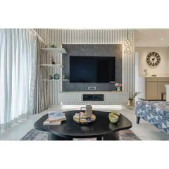 This living room features a custom-designed TV unit with a textured charcoal panel and vertical fluting on the wall. The combination of different materials and patterns adds depth and a sophisticated, tactile quality to the space.