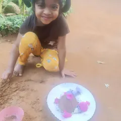 A duplicate of image 2, a heartwarming shot of a happy child and her mud creation.