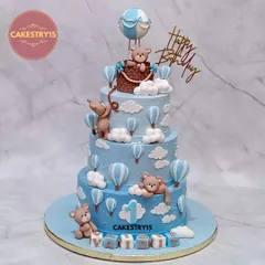For a grand first birthday, we designed this three-tier chocolate cake with a whimsical hot air balloon theme. It features handcrafted fondant teddy bears, fluffy clouds, and a personalized name block, making it a delightful spectacle for a child's special day.