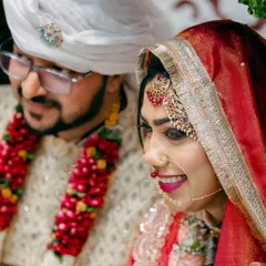 A candid shot of the bride and groom, capturing a natural moment of happiness during their wedding festivities.