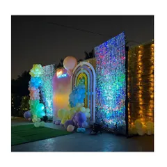 An impressive outdoor party setup at night, featuring large, sparkling shimmer walls, modern arched backdrops, and creative balloon arrangements.