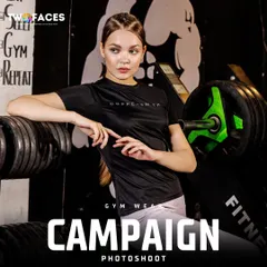 A model poses in a gym, surrounded by weights, wearing a black performance t-shirt. This authentic setting is perfect for a fitness brand that wants to connect with a dedicated gym-going audience.