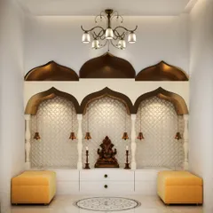 A grand and traditional mandir design with arched niches, hanging bells, and a beautiful inlay pattern on the floor. The ottomans provide comfortable seating for prayer.