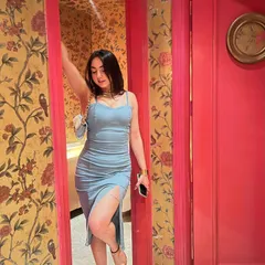 A dangerous combination: a beautiful dress and a pretty face. Posing in a gorgeous blue dress against a floral wallpaper, feeling confident and chic.